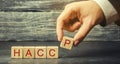 A man puts wooden blocks with the word HACCP. Hazard analysis and critical control points. Quality management rules for food Royalty Free Stock Photo