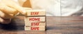 Man puts wooden blocks with the words Stay home stay safe. The concept of prevention from coronavirus infection. Self-isolation