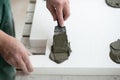 A man putsglue with putty knife on foam to stick it to the ceiling. Styrofoam, seiling mounting. Royalty Free Stock Photo