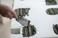 A man putsglue with putty knife on foam to stick it to the ceiling. Styrofoam, seiling mounting. Royalty Free Stock Photo