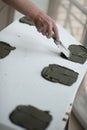 A man putsglue with putty knife on foam to stick it to the ceiling. Styrofoam, seiling mounting. Royalty Free Stock Photo