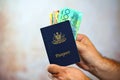 Man putting Australian money into passport Royalty Free Stock Photo