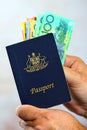 Man putting Australian money into passport Royalty Free Stock Photo