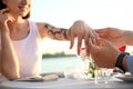 Man putting beautiful engagement ring on hand of his beloved outdoors Royalty Free Stock Photo