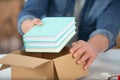 man putting books into box indoors Royalty Free Stock Photo