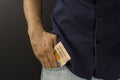 Man putting brazilian money inside the pocket Royalty Free Stock Photo