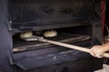 Man putting bread dough in the wood oven Royalty Free Stock Photo