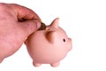 Man putting cent coin in a pink piggy bank. Isolated on wjite background