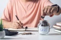 man putting coin in piggy bank and press the calculator with coins placed on the account book money saving concept Royalty Free Stock Photo