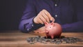Man putting coin into piggy bank for saving money concept, business finance and investment Royalty Free Stock Photo