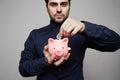 Man putting coin in piggy bank. Saving money concept. Close-up Royalty Free Stock Photo