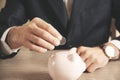 Man putting coin in piggy bank. saving money, finance concept, Royalty Free Stock Photo