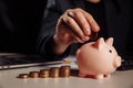 Man is putting coin in pink piggy bank close-up. Savings and investment concept Royalty Free Stock Photo