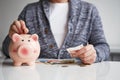 Man putting coin into small piggy bank Royalty Free Stock Photo