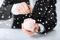 Man putting coin into small piggy bank Royalty Free Stock Photo