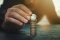 Man putting a coin with the word liberty on a money stack. Finance, banking, savings, personal budget, liberalism, increase in