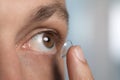 Man putting contact lens in his eye on background, closeup Royalty Free Stock Photo