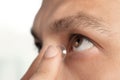 Man putting contact lens in his eye on white background, closeup Royalty Free Stock Photo