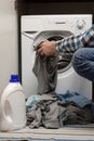 Man putting dirty clothes into washing machine Royalty Free Stock Photo