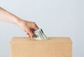 Man putting dollar money into donation box