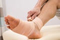 Man putting elastic bandage on foot