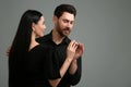 Man putting elegant ring on woman's finger against dark grey background. Space for text Royalty Free Stock Photo