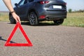 Man putting emergency stop sign near broken car Royalty Free Stock Photo