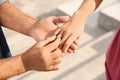 Man putting engagement ring on his girlfriend`s finger outdoors, closeup Royalty Free Stock Photo