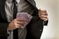 Man putting euros inside his jacket pocket