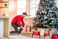 Man putting gifts under the New Year tree at home