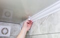 Man is putting gypsum baseboard with glue on ceiling. Maintenance repair works in the flat. Restoration indoors. Drywall panel Royalty Free Stock Photo