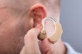 Man Putting Hearing Aid In His Ear Royalty Free Stock Photo