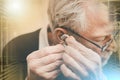 Man putting hearing aids; multiple exposure Royalty Free Stock Photo