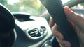 Man putting his hand on leather steering wheel against blazing sun