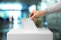 Man putting his vote into ballot box, closeup