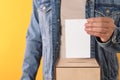 Man putting his vote into ballot box on yellow background, closeup