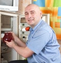 Man putting jug into refrigerator Royalty Free Stock Photo