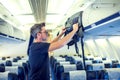 Man putting luggage on the top shelf on airplane Royalty Free Stock Photo