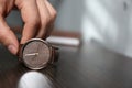 Man putting luxury wrist watch on table, closeup. Space for text Royalty Free Stock Photo