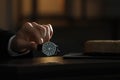 Man putting luxury wrist watch on table, closeup. Space for text Royalty Free Stock Photo