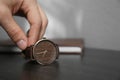 Man putting luxury wrist watch on table, closeup. Space for text Royalty Free Stock Photo