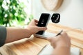 Man putting mobile phone onto wireless charger at wooden table, closeup. Modern workplace accessory Royalty Free Stock Photo