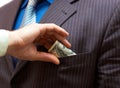 Man putting money into suit pocket Royalty Free Stock Photo