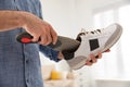 Man putting orthopedic insole into shoe at home