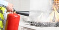 Man putting out burning cooktop with fire extinguisher in kitchen, closeup. Banner design Royalty Free Stock Photo