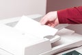 Man putting paper sheet on printer feed for scanning. Office work concept. Royalty Free Stock Photo