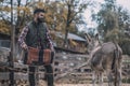 A man putting a saddle on a donkeys back