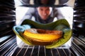 Man Putting Savoury Pie Into Oven To Bake