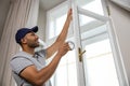 Man putting sealing foam tape on window indoors insulating his house. Royalty Free Stock Photo