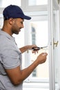 Man putting sealing foam tape on window indoors insulating his house. Royalty Free Stock Photo